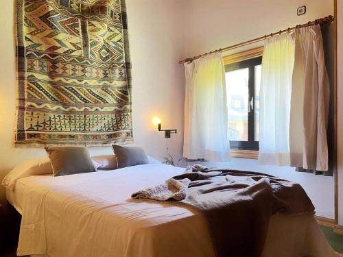 een slaapkamer met een groot bed en een raam bij Dúplex abuhardillado con vistas y parking in Vielha