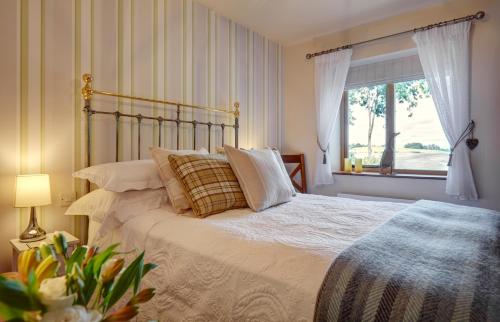 a bedroom with a large bed with a window at Upper Gelli Luxury Holiday Lodge, Converted Dairy & Cosy Shepherds Huts in Welshpool