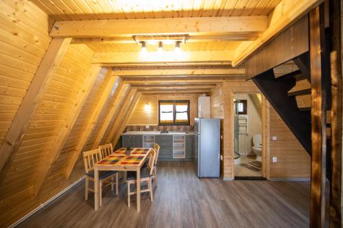 eine Küche mit einem Tisch und einem Kühlschrank in der Unterkunft Catunul din Podei A-Frame in Dragoslavele
