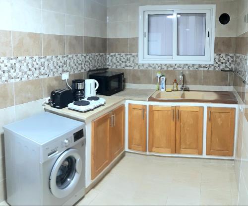 a kitchen with a washing machine and a sink at Chez Ayedi - central and familiar atmosphere next to beach in Hammam-Plage