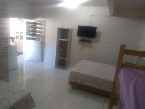 a room with two beds and a television in it at Pousada Rota do Parque in Penha