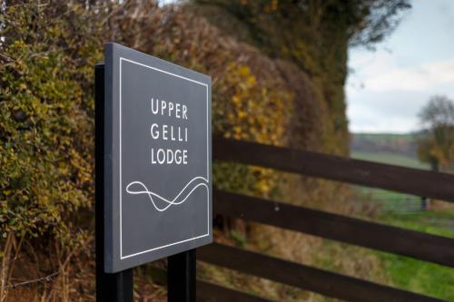 a sign that reads upper grill lodge next to a fence at Upper Gelli Luxury Holiday Lodge, Converted Dairy & Cosy Shepherds Huts in Welshpool