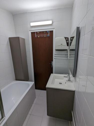 une salle de bain avec une baignoire, un lavabo et un miroir dans l'établissement Maison de village en Provence, à Saint-Roman-de-Malegarde