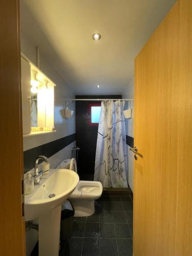 een badkamer met een witte wastafel en een toilet bij Country Lux Apartment near Airport in Markopoulon