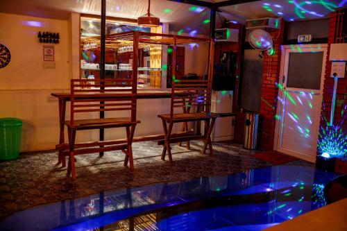 a bar with two chairs and a table in a room at Belljem Homes -your own private resort -2 BHK GF in Trichūr