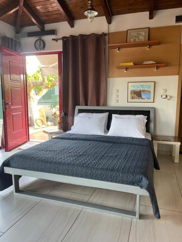 a bed in a room with a red door at Country Lux Apartment near Airport in Markopoulo