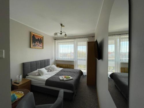 ヤストシェンビャ・グラにあるKojakのベッドと椅子付きのホテルルーム