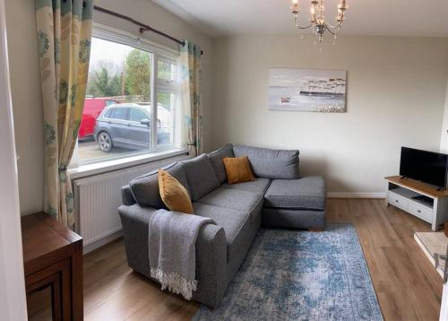 a living room with a couch and a window at Tullybrannigan Cottage Newcastle in Newcastle
