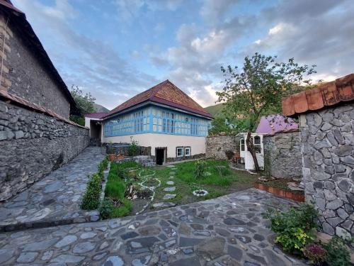 a large house with a blue and white building at Guest House Ruh Achari in Sheki