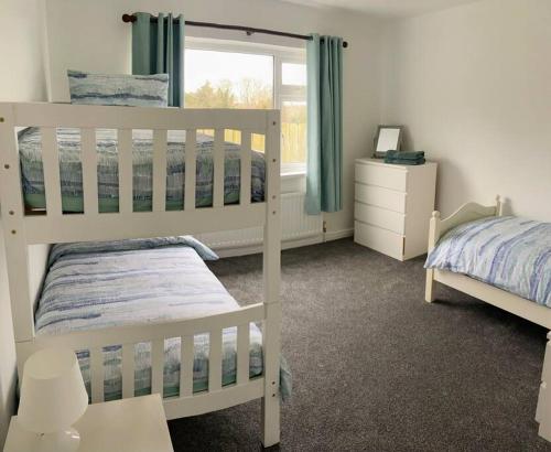 a bedroom with two bunk beds and a window at Tullybrannigan Cottage Newcastle in Newcastle