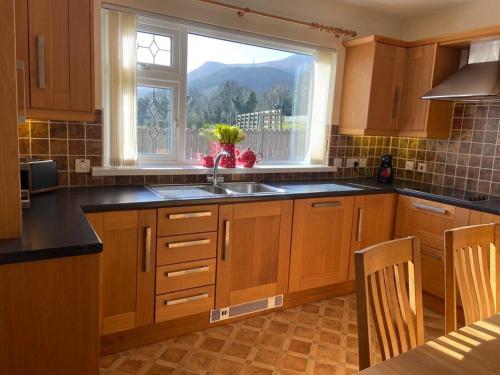 une cuisine avec un évier et une fenêtre dans l'établissement Tullybrannigan Cottage Newcastle, à Newcastle