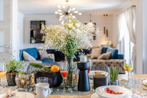 a dining room table with a vase of flowers at Holiday House Paula in Privlaka