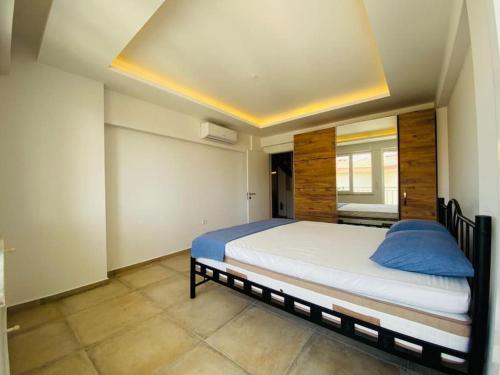 een slaapkamer met een groot bed in een kamer bij Full MANZARALı GENiŞ TeRaSLı HAVUZSUZ TATİL EVİ in Kuşadası