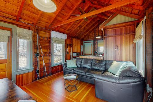 a living room with a leather couch in a cabin at Waterfront Serenity in Raymond