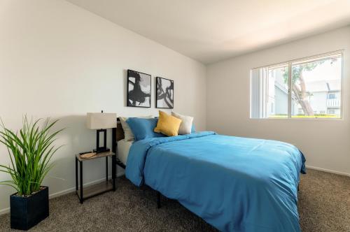 Un dormitorio con una cama azul y una ventana en "INACTIVE UNBOOKABLE - 5 mins from Disneyland and Convention Center - Your Perfect SoCal Getaway!", en Anaheim