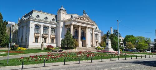 Genesis - Iasi City Center في ياش: مبنى ابيض كبير وامامه زهور