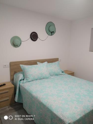 a bedroom with a bed with two lights on the wall at O RECUNCHO DE BERE in Ribadeo