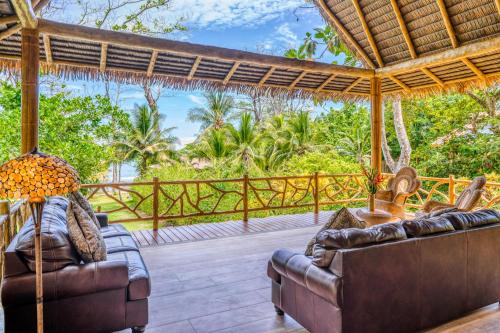 a living room with two couches on a deck at Casa Santa Maria in Cabo Matapalo