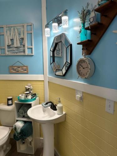 een badkamer met een wastafel, een toilet en een spiegel bij LOJ BNB in Morley