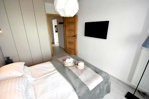 a bedroom with a bed with two baskets on it at Apartamenty Blanca in Łeba