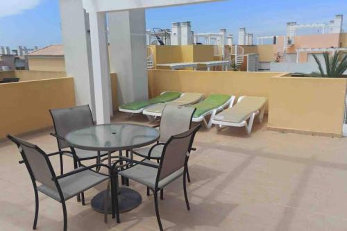 a patio with a table and chairs on a balcony at Royal Cabanas Gold penthouseT2 in Conceição