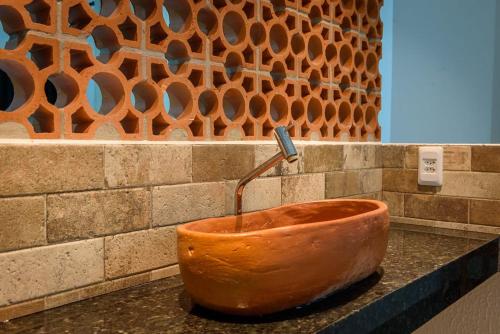 a large orange bowl sitting on top of a counter at POUSADA CAJU DO MATO in Prado