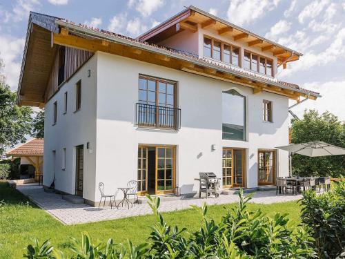 a large white house with tables and chairs at Wolke 9A in Traunstein