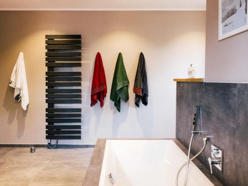 a bathroom with a bath tub and a towel rack at Wolke 9A in Traunstein