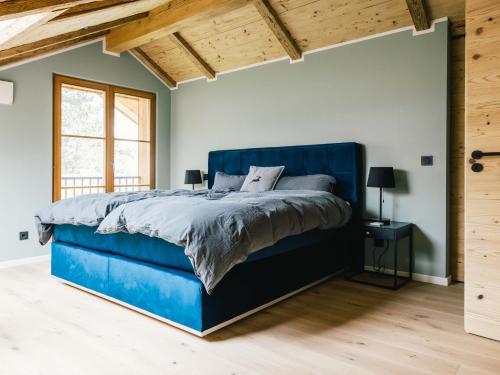 1 cama azul en un dormitorio con techo de madera en Wolke 9A en Traunstein