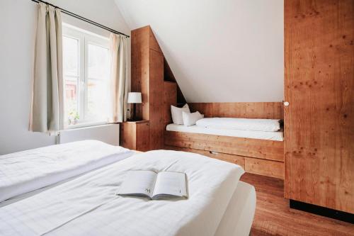 a bedroom with two beds and a book on the bed at Ferienhäuser im Torfhaus Harzresort, Torfhaus in Torfhaus
