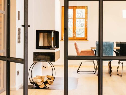 a living room with a fireplace and a chair at Wolke 9A in Traunstein
