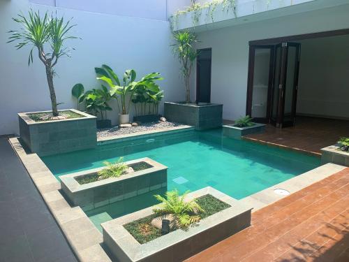 a swimming pool with plants in a building at Namdur Villa Sariwangi - Tropical Villa in Bandung With Private Pool in Bandung