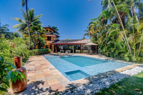 uma piscina em frente a uma casa com palmeiras em Pousada Villa N'kara em Itacaré