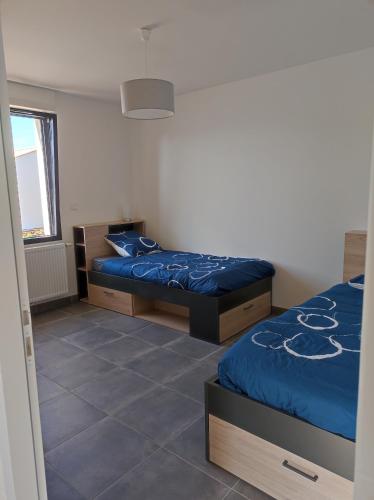 a bedroom with two beds and a window at maison angles in Angles