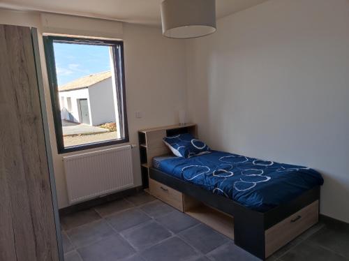 a small bedroom with a bed and a window at maison angles in Angles