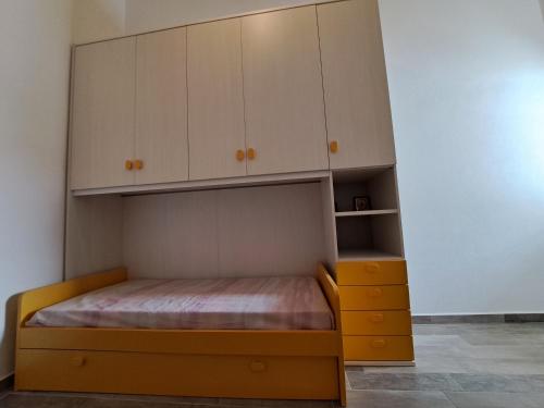 a bedroom with a bed and white cabinets at CASE ORCHIDEA - ROSA BLU in La Caletta