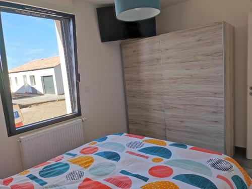 a bedroom with a bed and a large window at maison angles in Angles