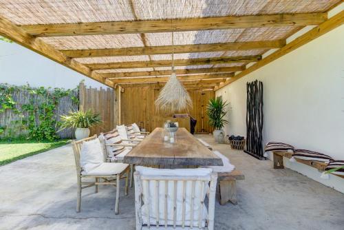 un patio con mesa de madera y sillas en Ocean House - Ribeira d'ilhas Ericeira, en Ericeira