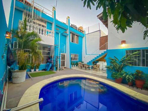 una casa azul con piscina frente a ella en Wandering Monkey Guesthouse, en Mazatlán