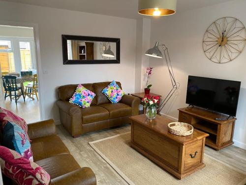 a living room with a couch and a tv at Comfortable new home in Isleham in Ely