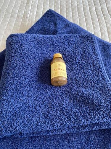 a bottle on a blue towel on a bed at Comfortable new home in Isleham in Ely