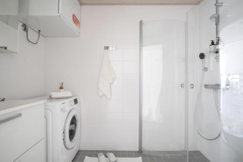a white bathroom with a washing machine and a shower at Woodrise Apartment 