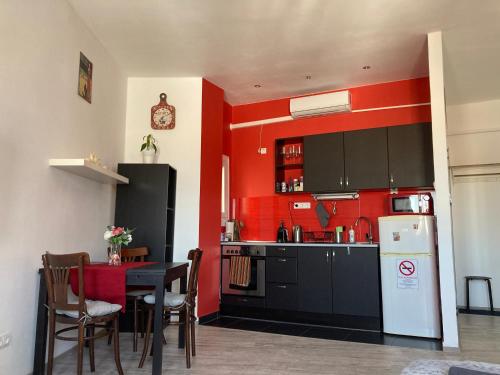 ブダペストにあるMester24 Apartmanの赤い壁のキッチン(テーブル、冷蔵庫付)