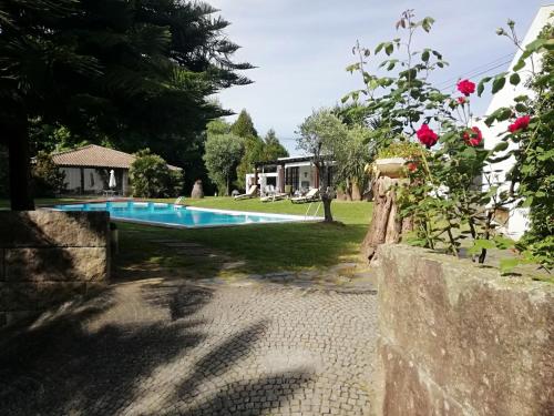 a swimming pool in a yard with a house at Casa da Boavista in Santa Maria Da Feira