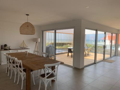 une cuisine et une salle à manger avec une table et des chaises en bois dans l'établissement Villa - Cap Blanc-Nez, à Sangatte