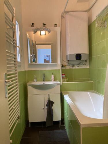 ein Badezimmer mit einem Waschbecken und einer Badewanne in der Unterkunft Mester24 Apartman in Budapest