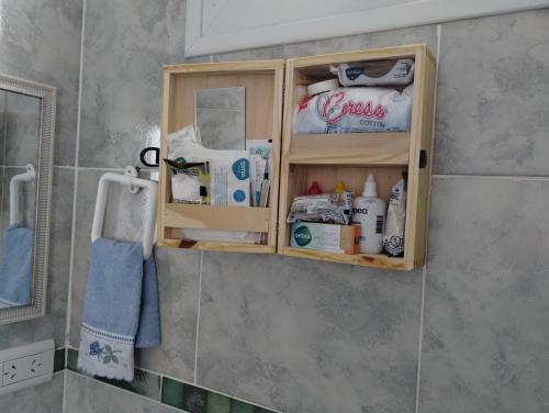 a wooden medicine cabinet with toiletries in a bathroom at LuMar3 in Comodoro Rivadavia