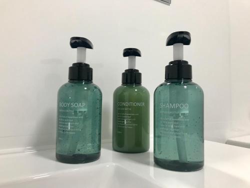 three bottles of detergent sitting on top of a sink at Light in Vila-real, central apartment with office in Villareal