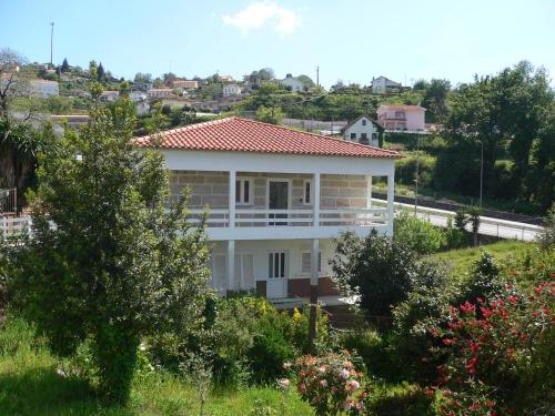 a white house with a red roof on a hill at Maria João in Paredes de Coura