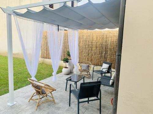 a pergola with chairs and tables on a patio at Piccola Dimora B&B in Lucca